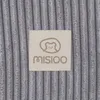A close-up of a beige label with a bear logo and the brand name 'MISIOO' on a ribbed gray fabric. Produktbild-Vorschau