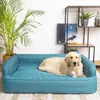 A golden retriever dog is resting on a blue dog bed in a living room setting. Náhľad obrázku produktu