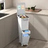 A white multi-compartment trash can with a lid open, filled with trash and recycling, sits in a kitchen setting. Voir les images du produit