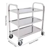 A three-tier stainless steel kitchen trolley with wheels, shown from a three-quarter angle against a white background. Dimensions are indicated with measurement lines and text. Voir les images du produit