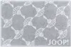 A close-up, top-down view of a gray bath mat with a repeating white pattern and the brand name "JOOP!" printed in the bottom right corner.