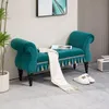 A teal velvet bench with tassels and a white throw blanket is placed in a room with a plant and slippers nearby. Náhľad obrázku produktu