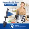 A woman smiling in a kitchen with a Thermomix TM21 and a spatula. Produktbild-Vorschau