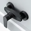 A black shower faucet is mounted on a white wall. Produktbild-Vorschau