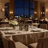 A beautifully set dining table in a restaurant at night, with candles and flowers. Produktbild-Vorschau