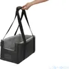 A hand holding a black dog car seat with gray interior. Produktbild-Vorschau