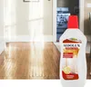A bottle of wood polish is placed in front of a wooden floor in a hallway, with a kitchen visible in the background. Náhľad obrázku produktu
