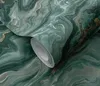 A close-up view of a roll of marble-patterned wallpaper in petrol green with gold accents. Produktbild-Vorschau