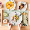 A table setting with plates of food and cutlery, suggesting a meal. Produktbild-Vorschau