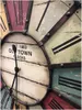A close-up view of a vintage-style wall clock with Roman numerals and distressed wood-like sections. Anteprima dell’immagine prodotto