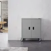 A gray metal cabinet with two doors and wheels is shown in a modern room with white marble walls. Produktbild-Vorschau