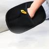 A hand wearing a black pet grooming glove with a yellow loop. Produktbild-Vorschau