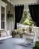 A porch swing and rocking chair on a porch with black outdoor curtains. Náhľad obrázku produktu