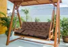 A brown cushion on a wooden swing chair on a patio. Produktbild-Vorschau