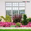 A well-maintained garden bed with vibrant pink flowers and lush green plants in front of a house with a large window. Produktbild-Vorschau