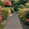 A garden path made of grey planks winds through a lush garden filled with pink and yellow flowers and green bushes. Náhľad obrázku produktu