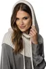 A woman wearing a beige hooded scarf over a gray shirt. Produktbild-Vorschau