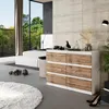 A modern bedroom with a dresser, bed, and large window overlooking a garden. Voir les images du produit