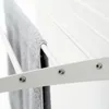 A close-up shot of a white wall-mounted drying rack with a gray towel hanging on it. Produktbild-Vorschau