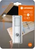 The product is packaged in a cardboard box with a clear plastic window, showing the LEDVANCE NIGHTLUX TORCH motion sensor light. The background depicts a wooden attic or ceiling structure, illustrating the product's intended use. Produktbild-Vorschau