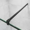 A close-up view of a black metal frame and green glass edge of a shower enclosure against a tiled wall. Produktbild-Vorschau
