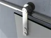 A close-up view of a sliding glass door hardware system mounted on a wall. Náhled obrázku produktu