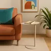 A modern living room setting with a sofa, a side table, and a plant. Produktbild-Vorschau