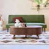 A living room scene featuring a green sofa, a wooden coffee table, and a patterned rug. Produktbild-Vorschau