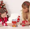 A mother and daughter are playing with a Santa Claus figurine climbing a chimney. Voir les images du produit