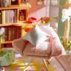 A close-up of a miniature dollhouse armchair with a pillow. Anteprima dell’immagine prodotto