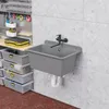 A gray sink with a black faucet is mounted on a concrete wall in a workshop or garage setting. Storage bins and tools are visible in the background. Produktbild-Vorschau