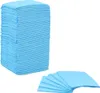 A stack of blue disposable puppy training pads and a fanned out stack of pads. Produktbild-Vorschau