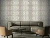 A living room scene with a sectional sofa, two accent chairs, and a coffee table in front of a wall decorated with 3D wall panels. Produktbild-Vorschau