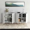 A white console table with open doors and shelves displaying various decorative items and storage boxes, set against a textured gray wall and wooden floor. Produktbild-Vorschau