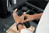 A person is holding a black thermos in a kitchen setting. Podgląd zdjęcia produktu