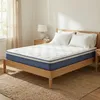 A mattress on a wooden bed frame in a bedroom. Produktbild-Vorschau