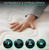 A child's hand resting on a soft mattress, with feature icons at the bottom. Produktbild-Vorschau