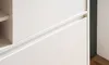 A close-up view of a white cabinet with a recessed handle detail. Produktbild-Vorschau