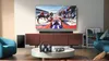A living room setup with a TV, soundbar, and gaming accessories. Náhled obrázku produktu