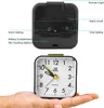 A black analog alarm clock is shown from the back and front, with labels pointing out its features. The front view shows the clock face held in a hand. Produktbild-Vorschau