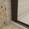 A close-up view of a shower enclosure corner, showing the frame and glass meeting the wall and base. Produktbild-Vorschau