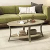 A living room scene with a green sofa and a light brown oval coffee table. Produktbild-Vorschau