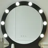 A close-up of a black vanity mirror with LED lights, showing a reflection of a white wall and some cosmetic bottles on the counter below. Voir les images du produit