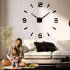 A mother and daughter are sitting on the floor in front of a couch, with a large wall clock in the background. Produktbild-Vorschau