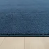 A close-up, low-angle shot of a blue rug on a light wood floor. Produktbild-Vorschau