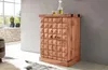 A wooden bar cabinet with a textured front is shown in a room setting with a window and plants in the background. Produktbild-Vorschau