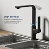 A black kitchen faucet is shown over a double stainless steel sink with water. Produktbild-Vorschau