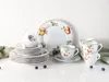 A set of porcelain dishes with fruit illustrations, including plates, cups, and saucers, arranged on a white surface. Náhľad obrázku produktu
