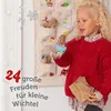 A young girl is opening an advent calendar. Produktbild-Vorschau