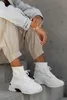 A person sitting on stairs, wearing casual clothing and white high-top sneakers. Produktbild-Vorschau